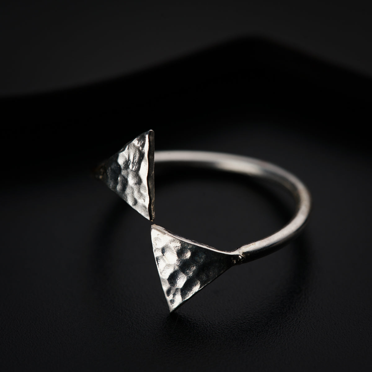 a close up of a silver ring on a black surface