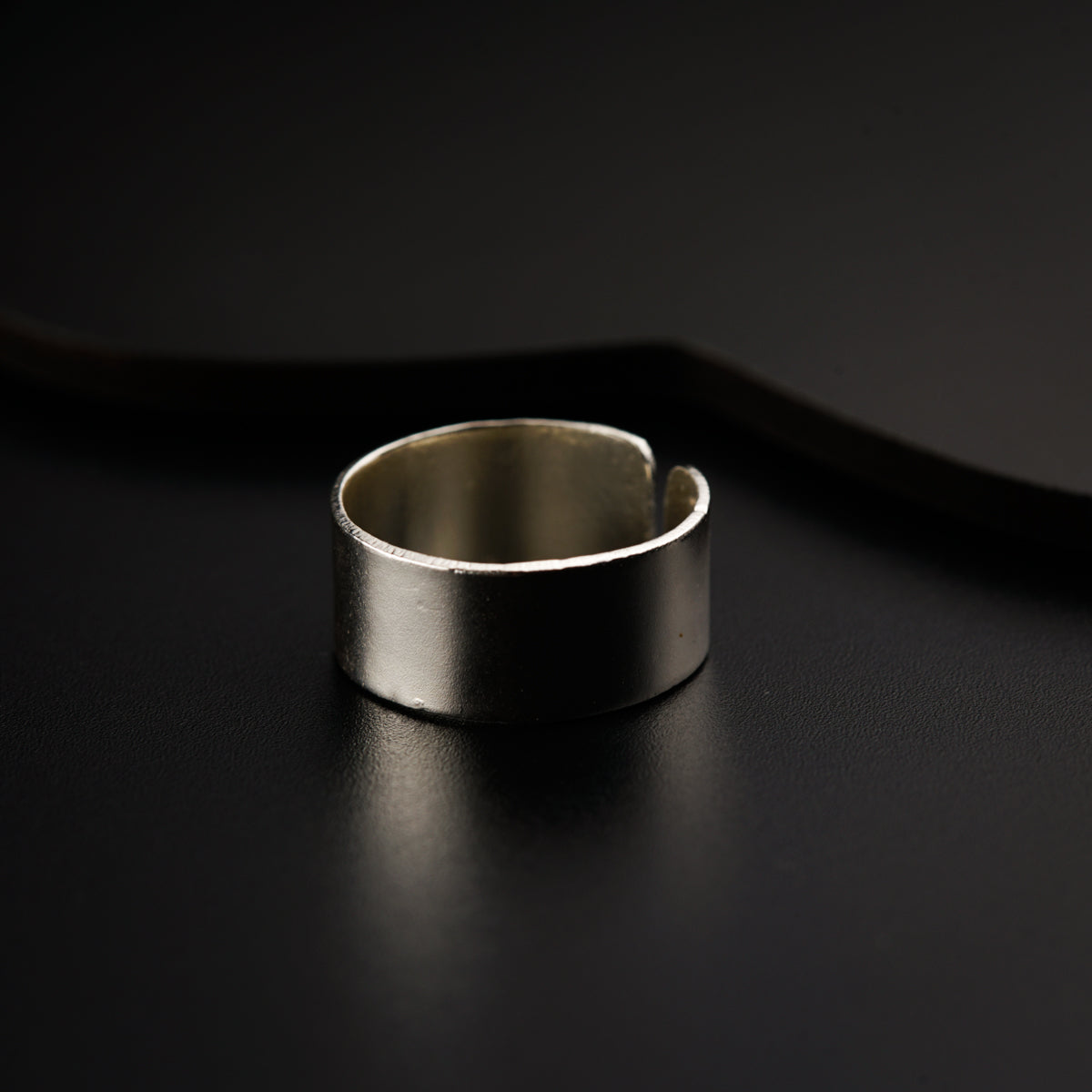 a silver ring sitting on top of a black table