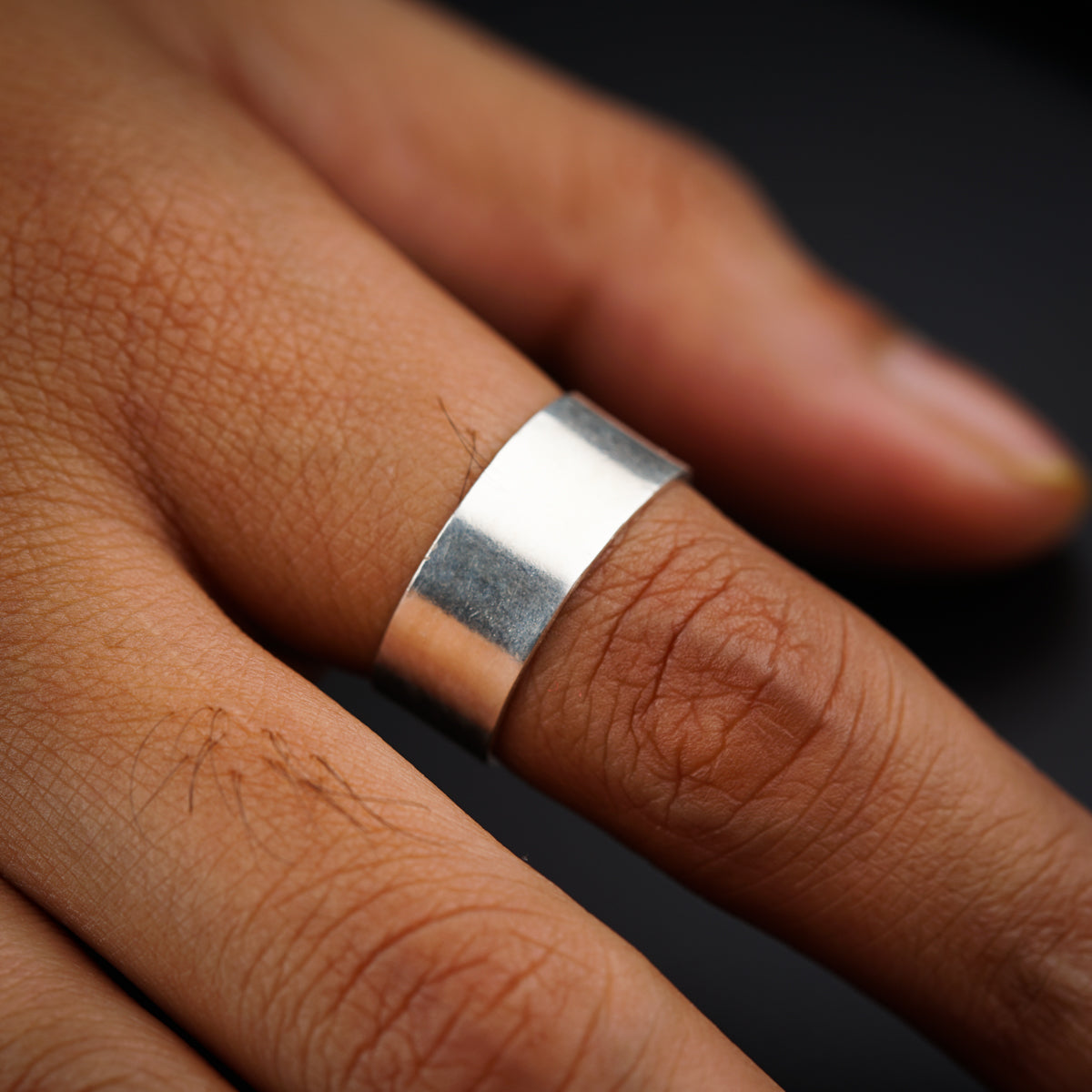 a close up of a person's hand with a ring on it