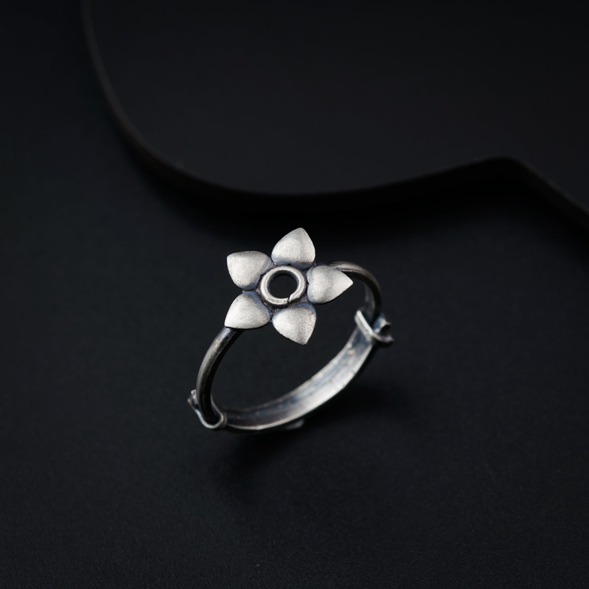 a silver ring with a flower on it