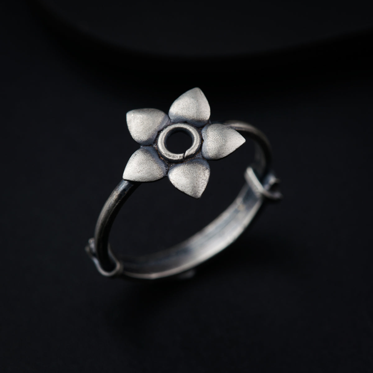 a silver ring with a flower on it