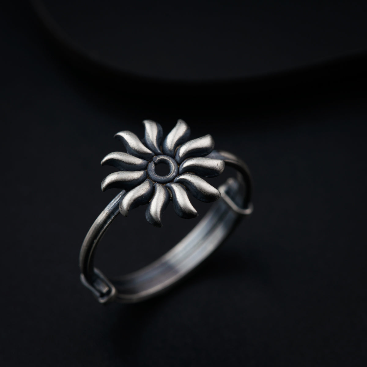 a silver ring with a flower design on it