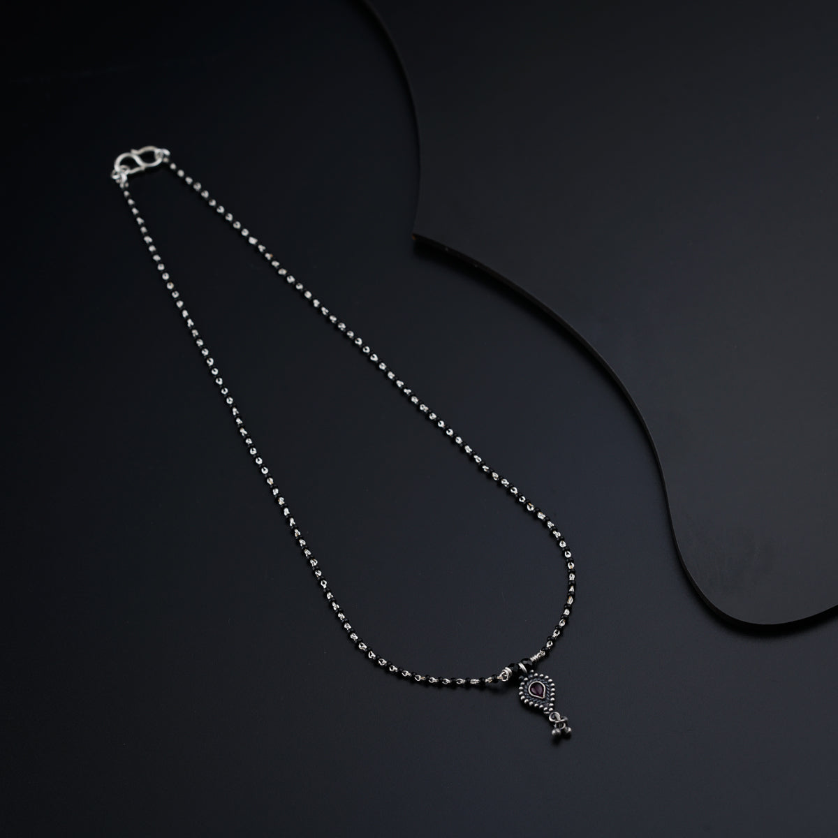 a necklace with a cross on a black background