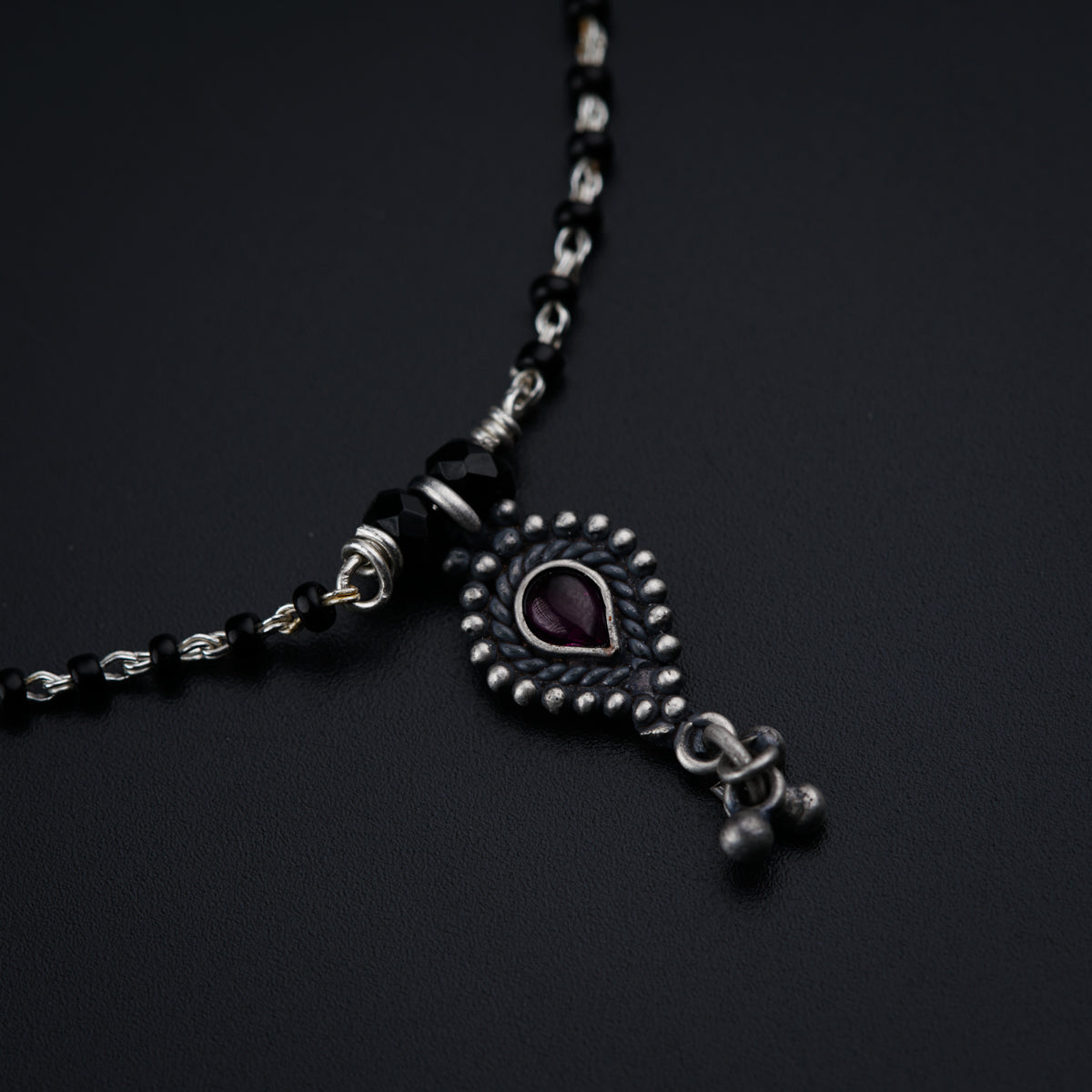 a black and silver necklace with a heart on it