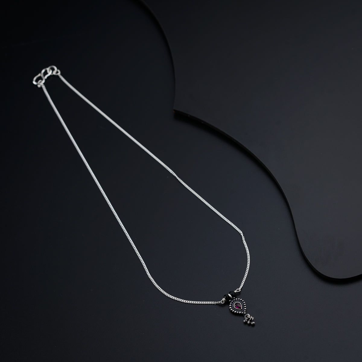 a necklace with a heart on a black background
