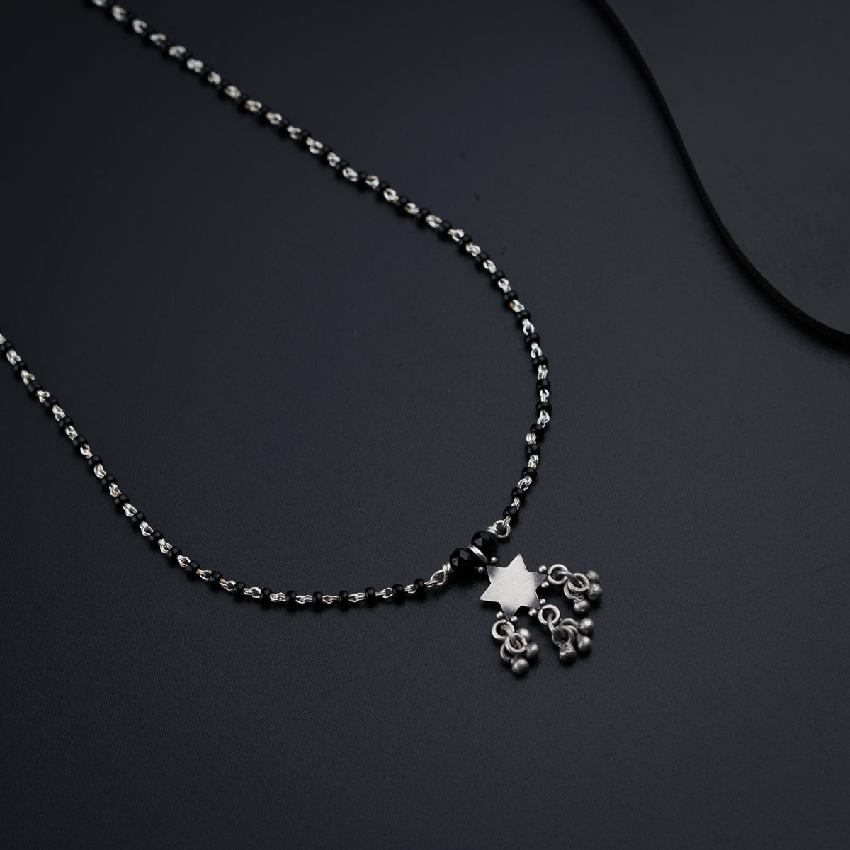a necklace with a cross on a black surface