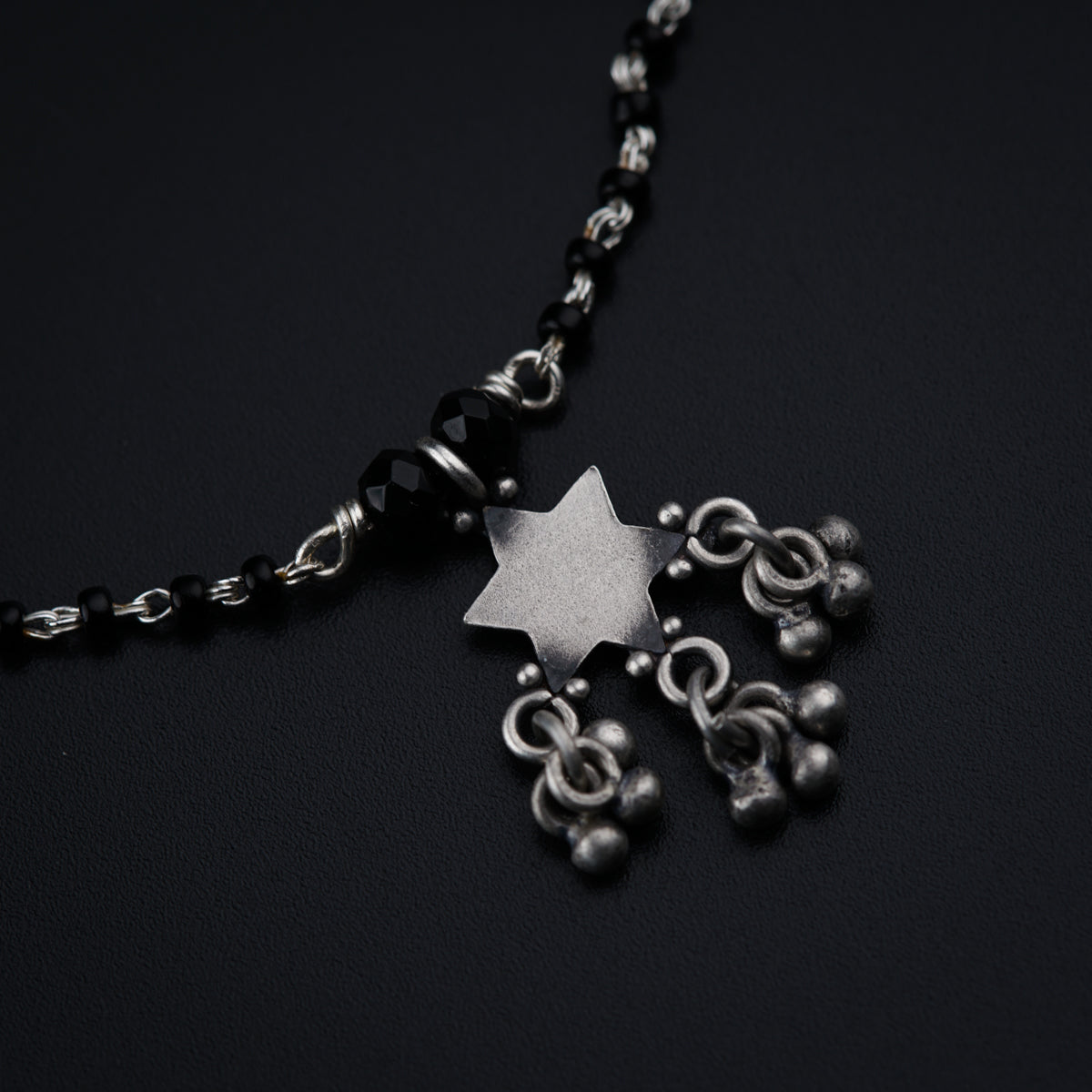 a black and silver necklace with a star on it