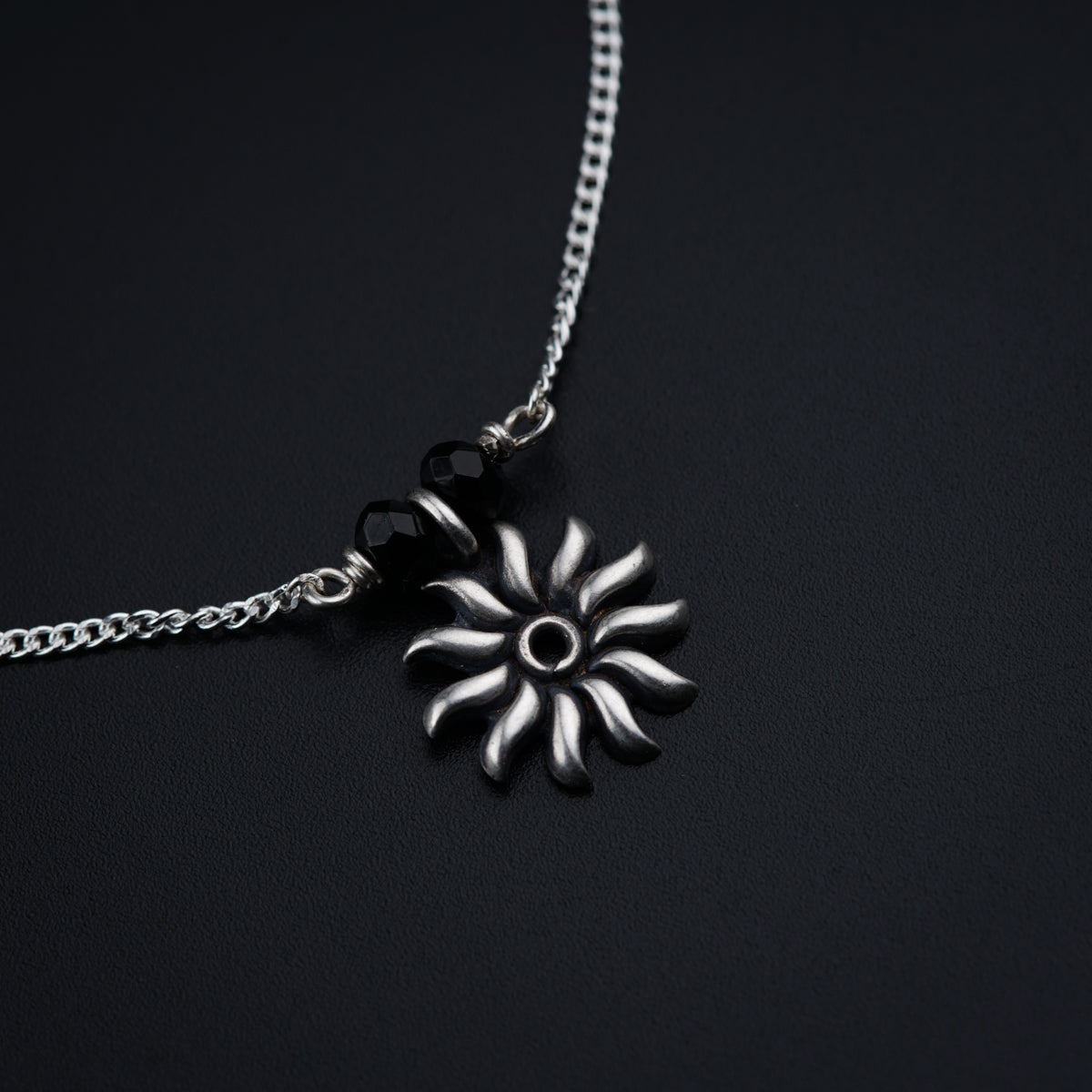 a black and white photo of a flower on a chain