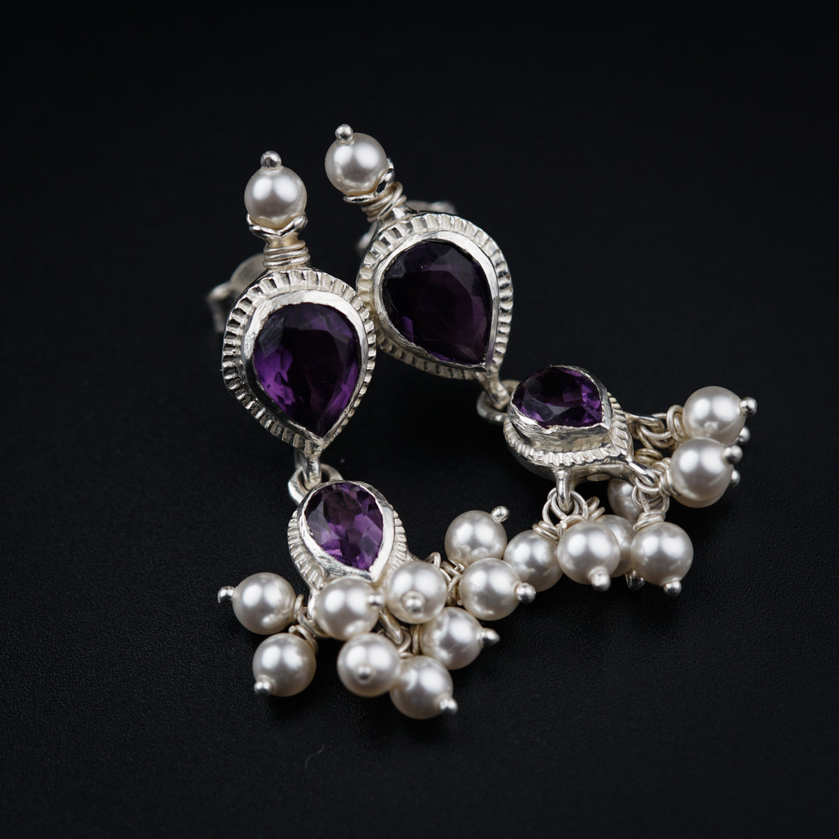 a close up of a pair of earrings with pearls