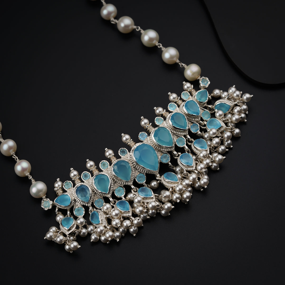 a close up of a necklace on a black surface