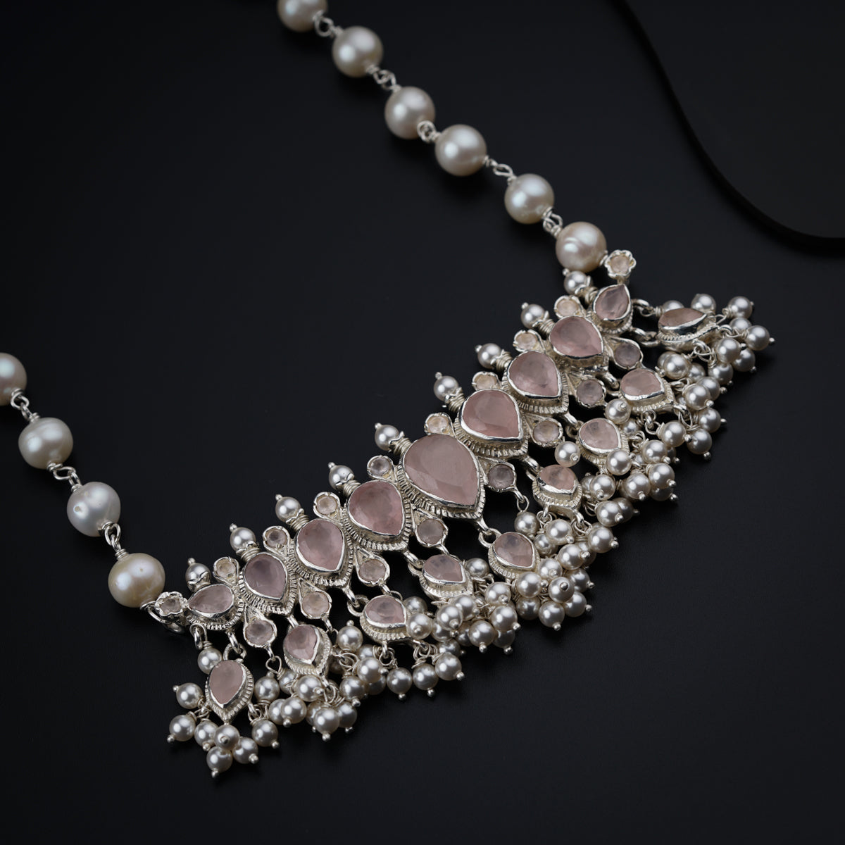 a close up of a necklace with pearls