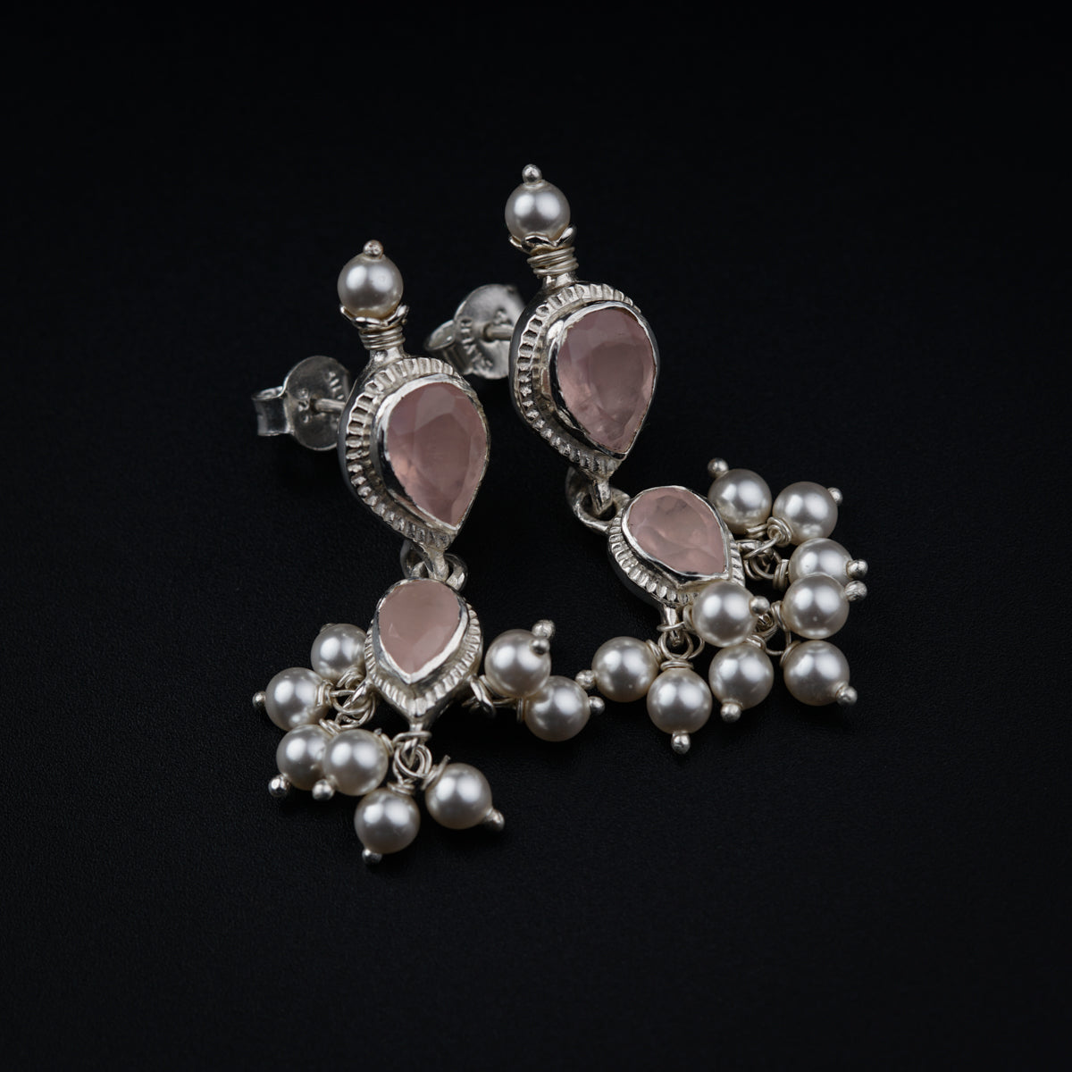a pair of earrings with pearls and pink stones