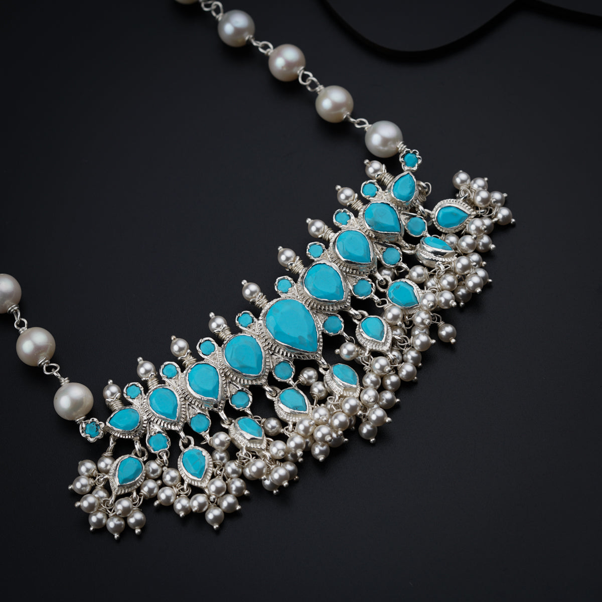 a close up of a necklace on a black surface