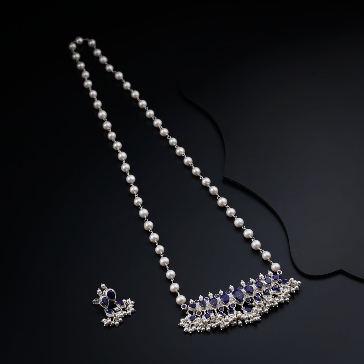a necklace with a tiara and a pair of pearls