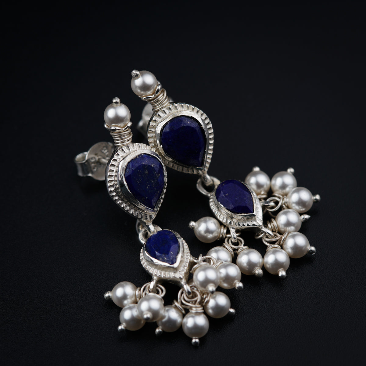 a close up of a pair of earrings on a black surface