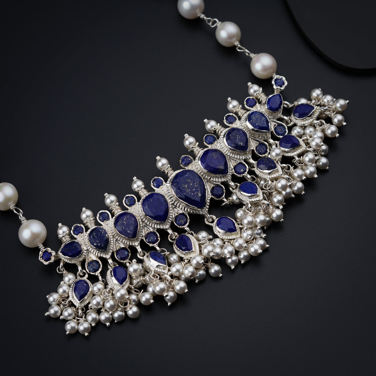 a close up of a necklace on a black surface