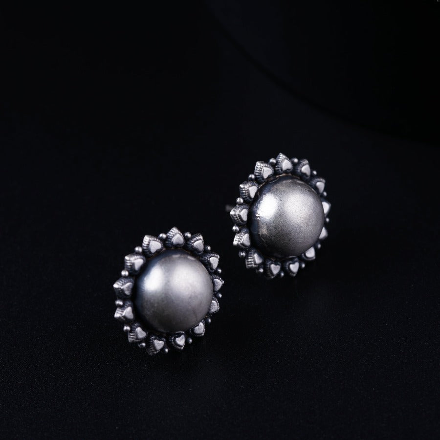 a pair of earrings on a black surface