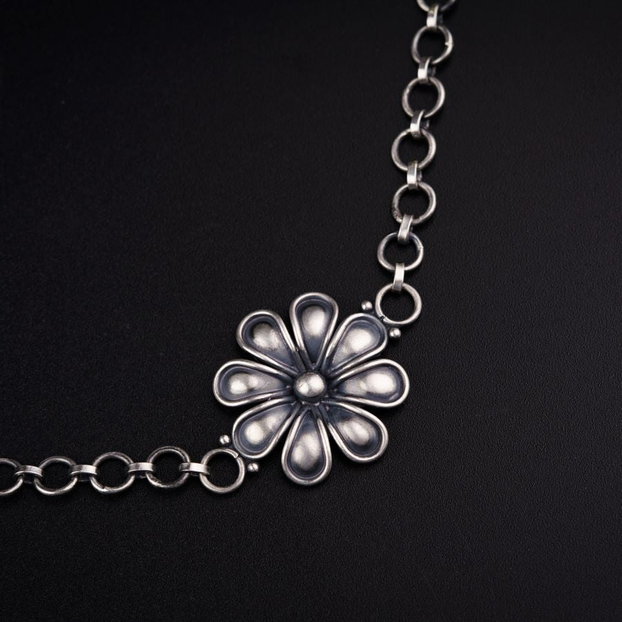 a silver chain with a flower on it