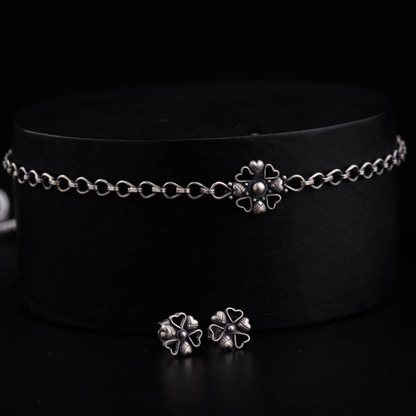 a black hat with two silver clovers on it