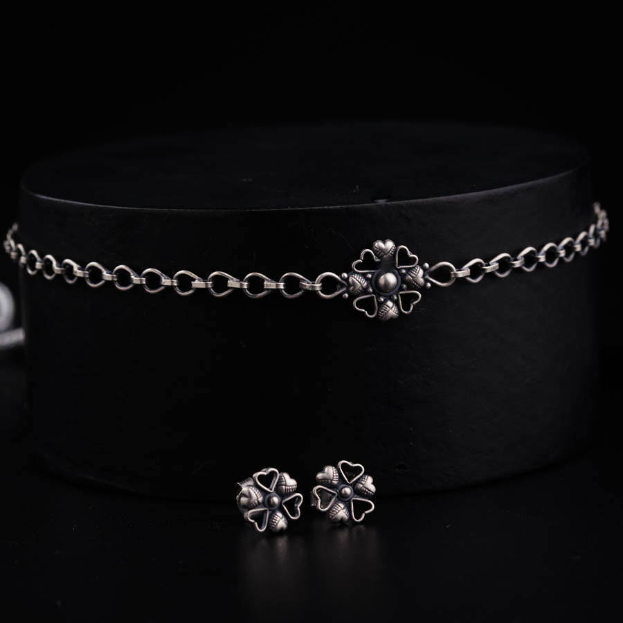 a black hat with two silver clovers on it