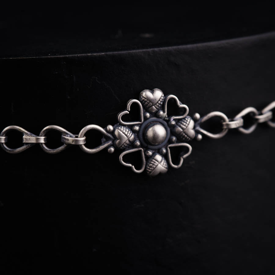 a close up of a metal chain with a cross on it