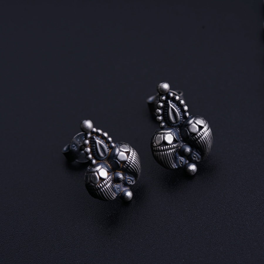 a pair of silver earrings sitting on top of a table