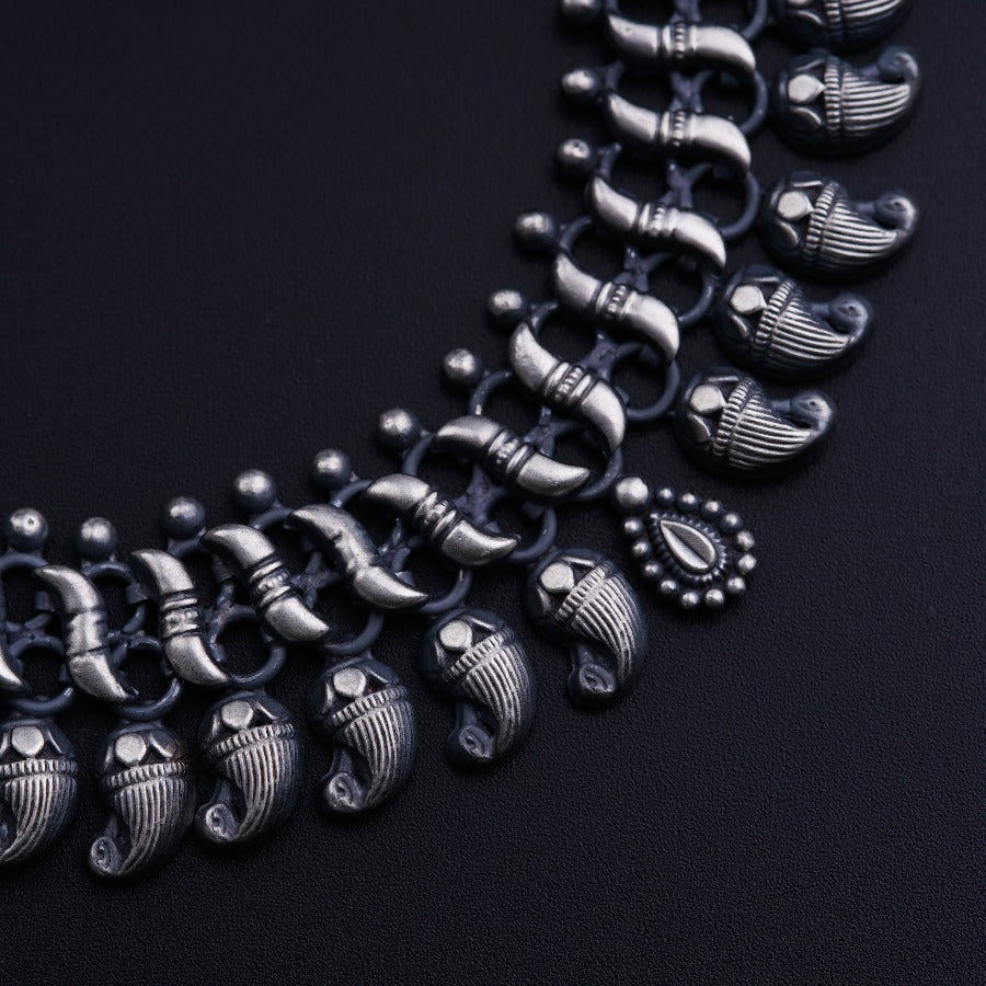 a black necklace with silver details on a black background