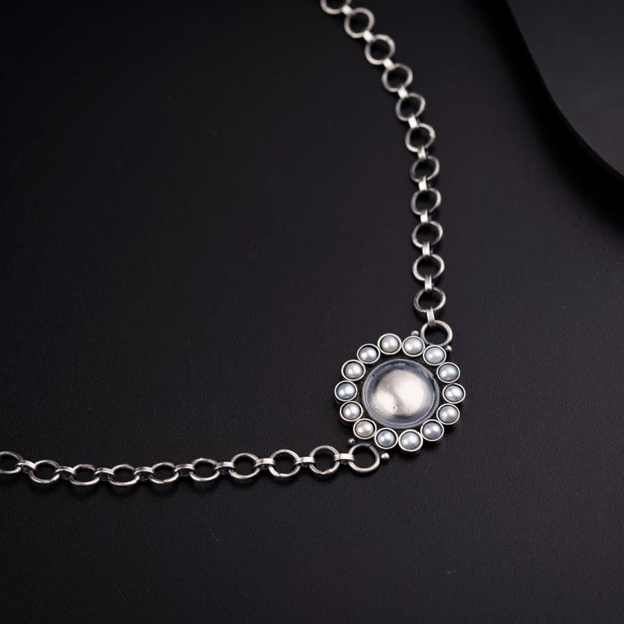 a close up of a necklace on a black surface