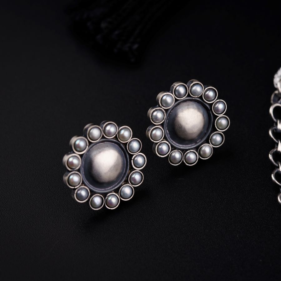 a pair of silver earrings sitting on top of a table