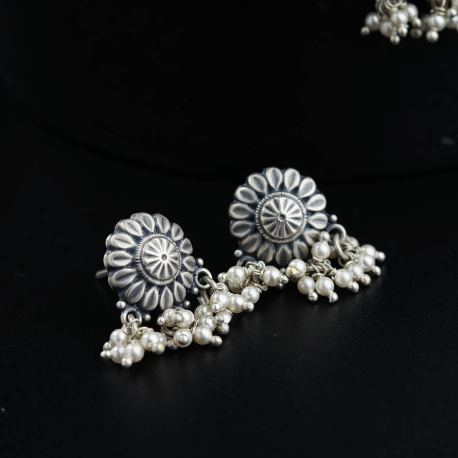 a close up of a pair of earrings on a black surface