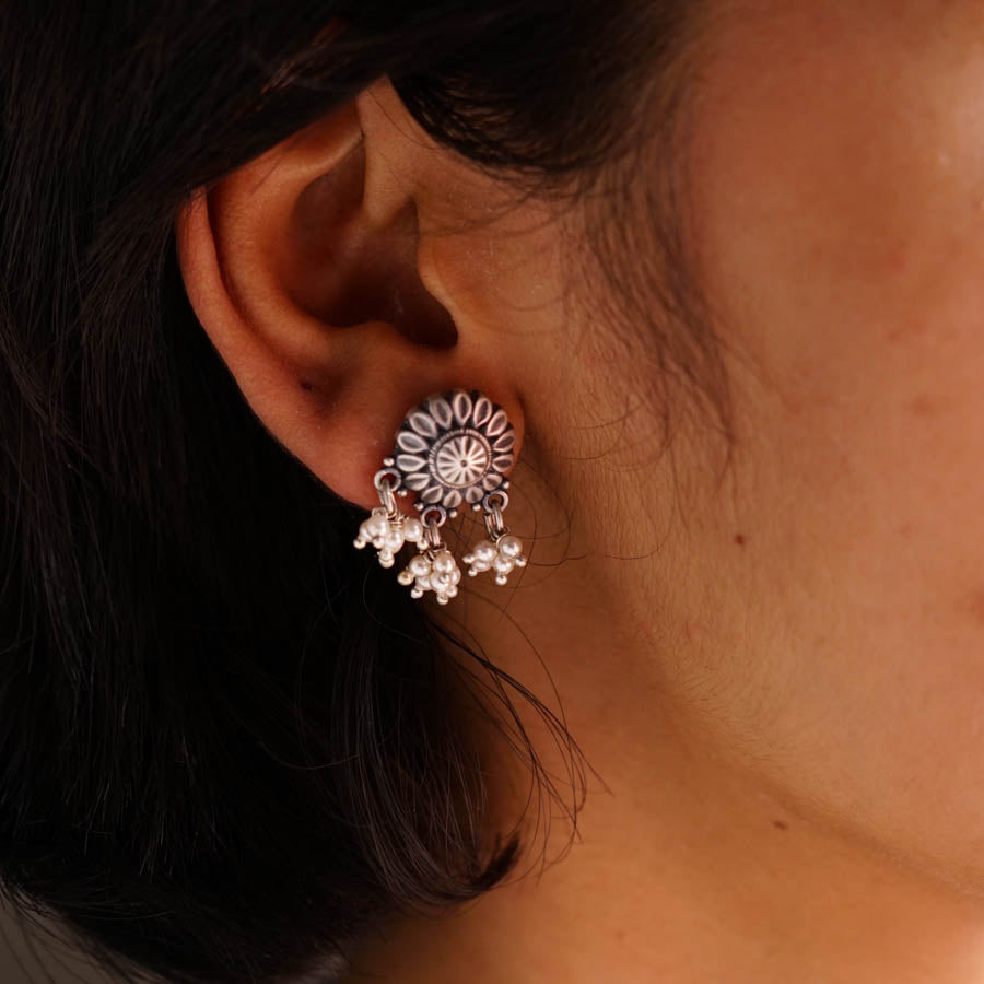 a close up of a person wearing a pair of earrings