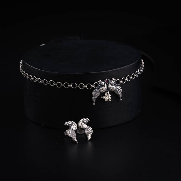 a black hat with two silver birds on it