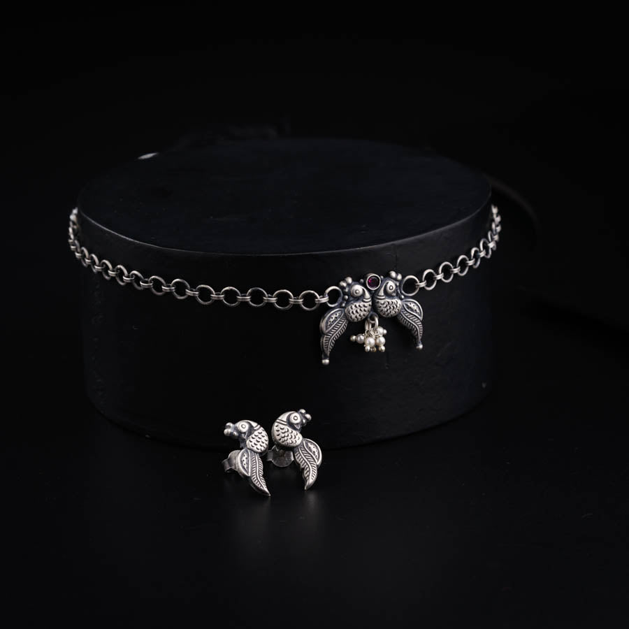 a black hat with two silver birds on it