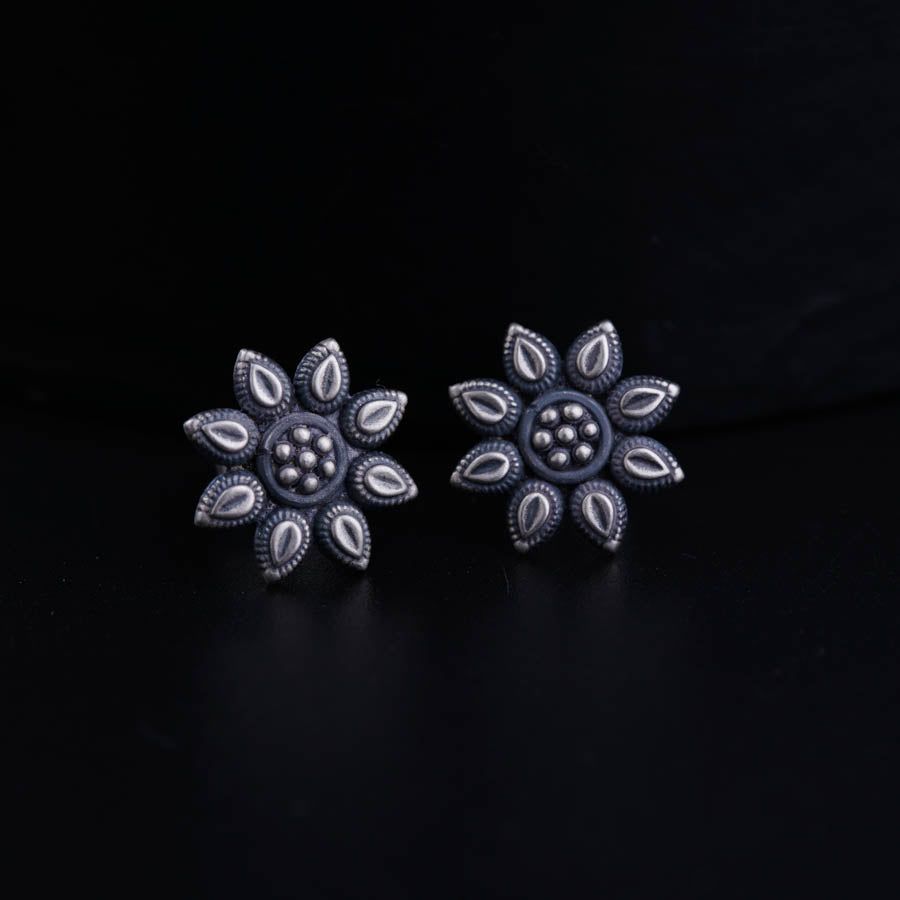 a pair of earrings on a black surface