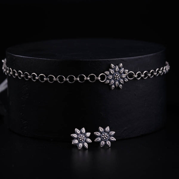 a black hat with two silver flowers on it
