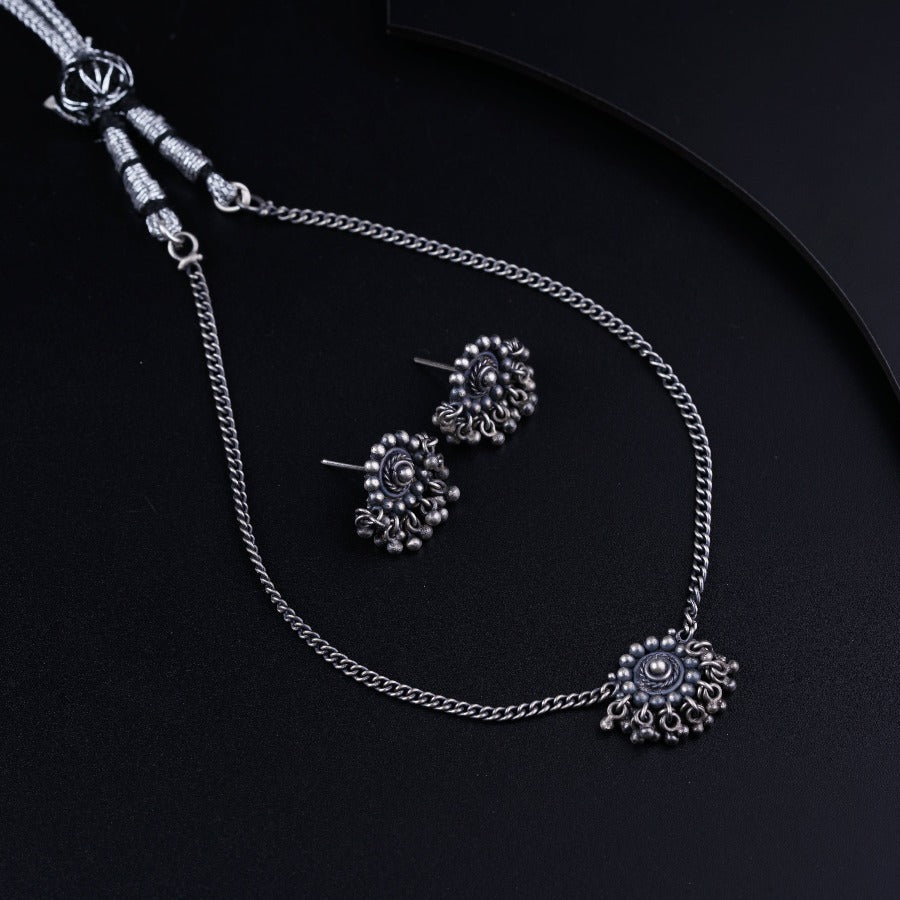 a necklace and earring set on a black surface