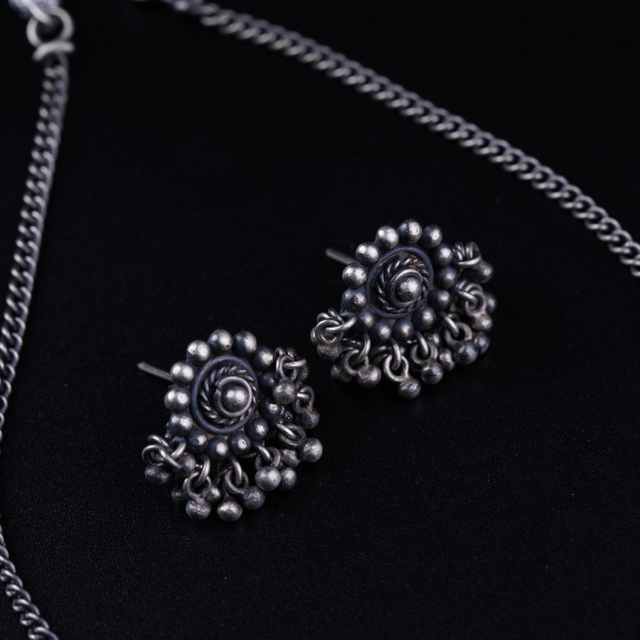 a close up of a pair of earrings on a chain