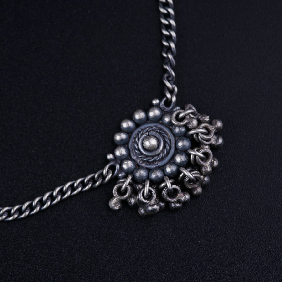 a silver necklace with a circular design on it