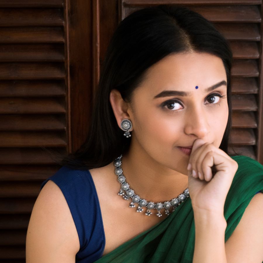 a woman wearing a green sari and a necklace
