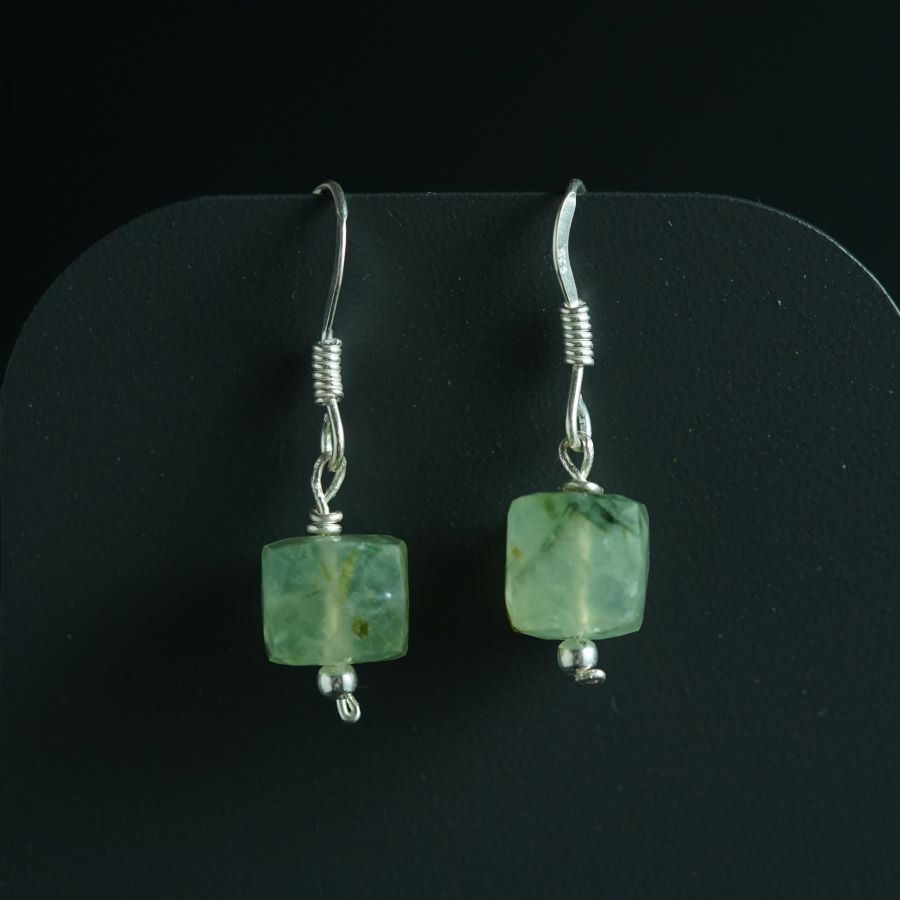 a pair of earrings with green glass beads
