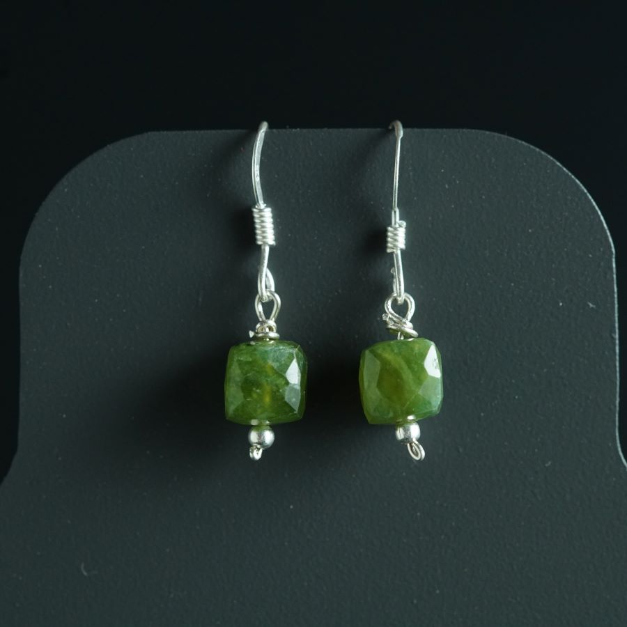 a pair of earrings with green glass beads