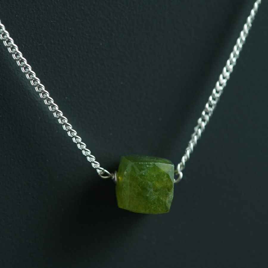 a necklace with a green stone on it