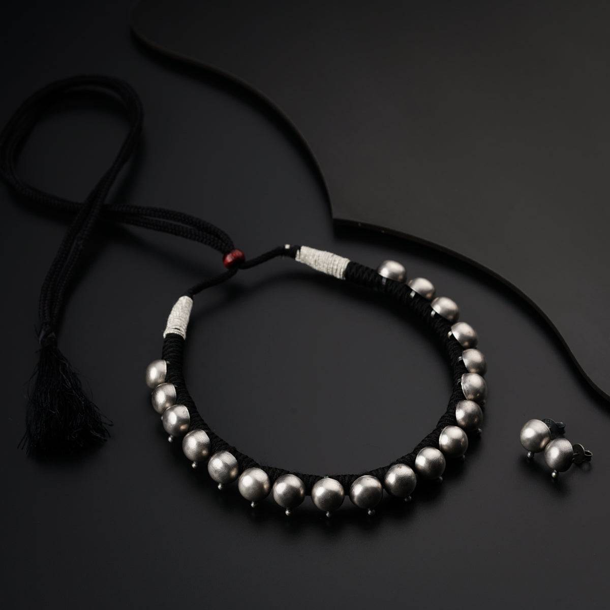 a bracelet with silver beads and a tassel