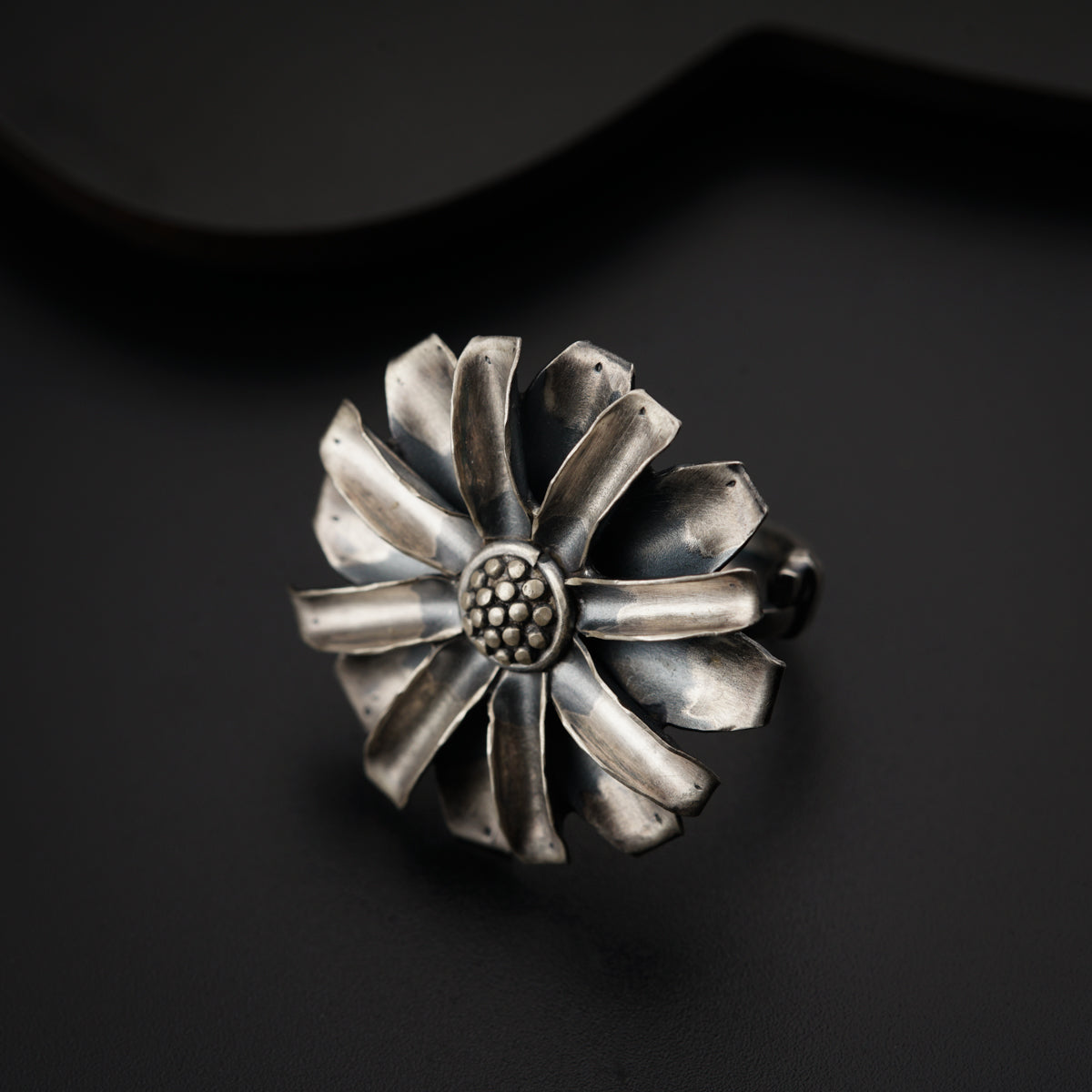 a metal flower ring sitting on top of a table