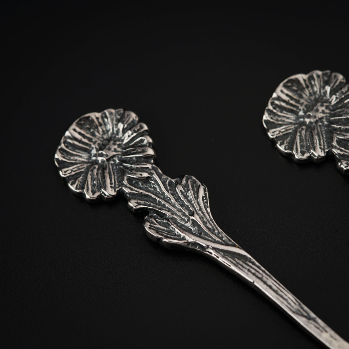 a pair of silver spoons sitting on top of a table