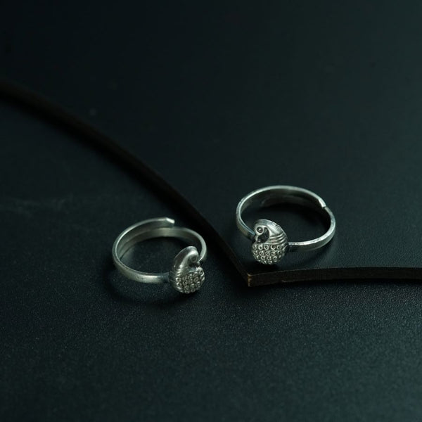 a pair of silver rings sitting on top of a black surface