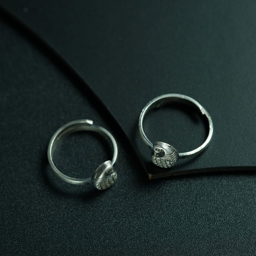 a pair of silver rings sitting on top of a black surface