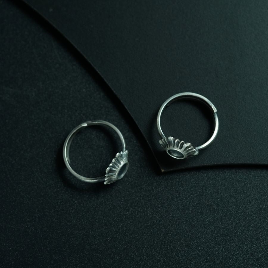 a pair of silver rings sitting on top of a black surface