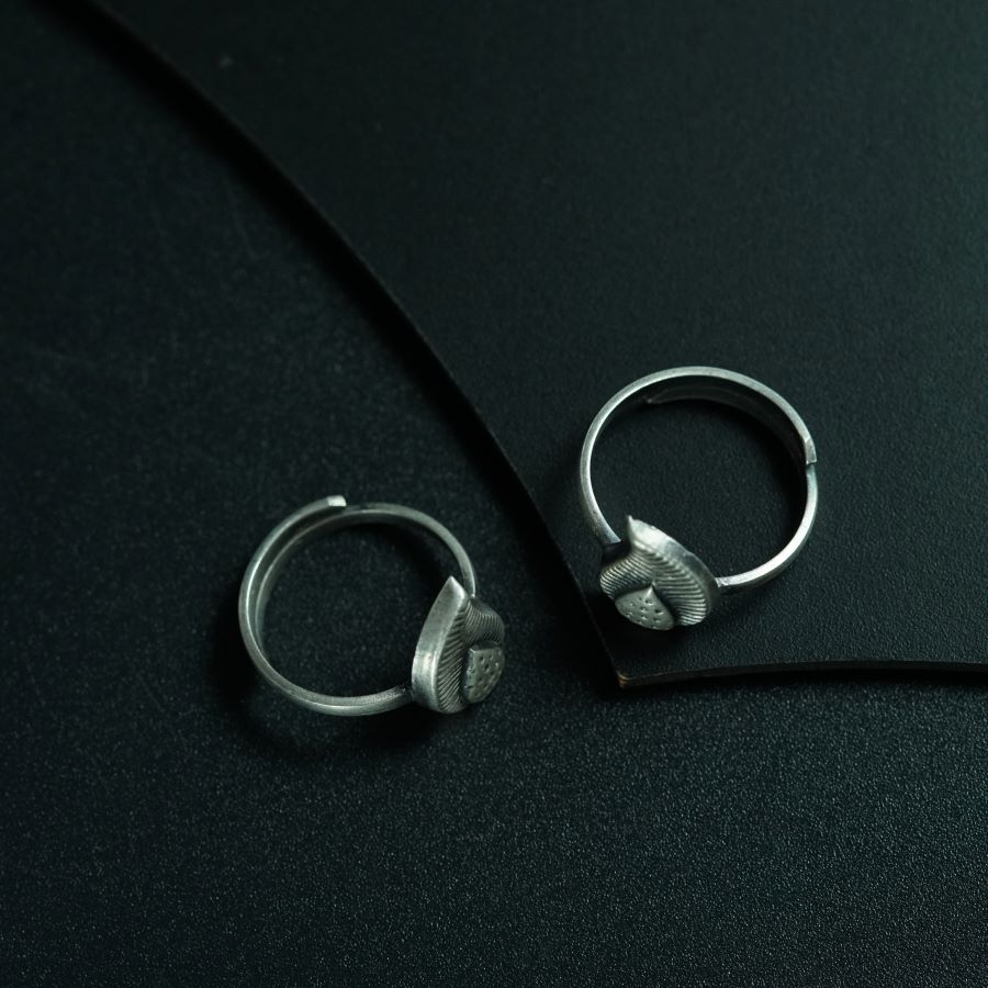 a pair of silver hoop earrings sitting on top of a black surface