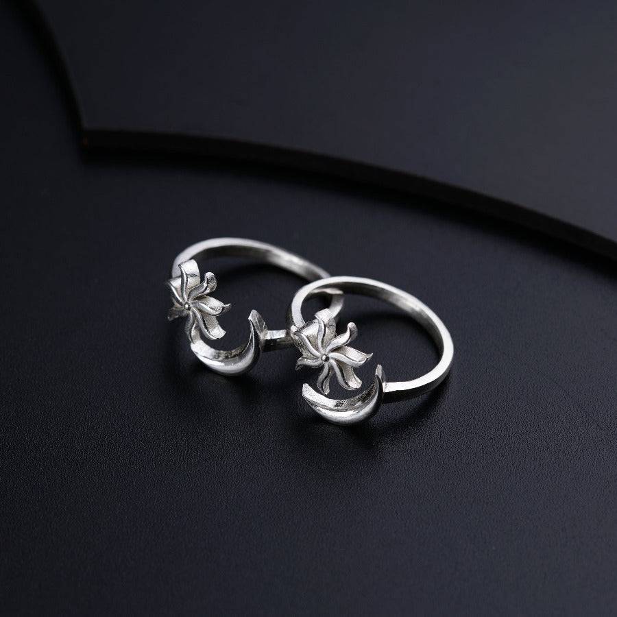 a pair of silver rings on a black surface